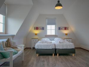 a bedroom with a bed and a chair in a attic at Waddenhuis in Westerland +43 photos