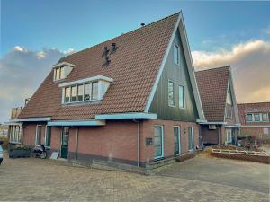 a large house with a brown and green roof at Waddenhuis in Westerland