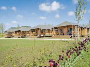 a group of lodges in a field with flowers at Glamping Lodge in Westerland