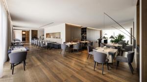 a restaurant with tables and chairs in a room at Hilton Lake Como in Como