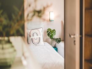 a bedroom with a bed with a pillow and a plant at Wadden Lodge Plus in Westerland +16 photos