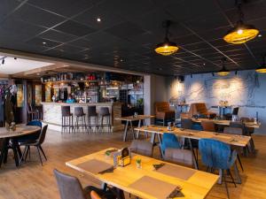 a restaurant with wooden tables and chairs and a bar at Wadden Lodge Plus in Westerland