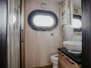 a small bathroom with a sink and a toilet at Tiny Houseboat De Woudaap - I in Uitgeest +20 photos