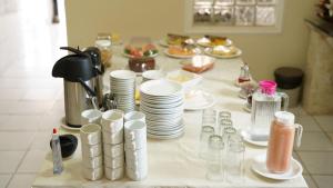 a table with plates and cups and dishes on it at Pousada Casa do Professor in Barreirinhas