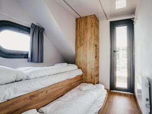 a room with three beds on the wall at Tiny Houseboat De Woudaap - I in Uitgeest