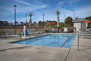 a swimming pool with lounge chairs and umbrellas at Hampton Inn Yemassee/Point South, Sc in Yemassee
