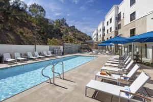 a pool at a hotel with chairs and umbrellas at Homewood Suites by Hilton San Diego Hotel Circle/SeaWorld Area in San Diego