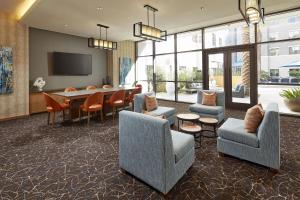 a lobby with chairs and a table and a dining room at Homewood Suites by Hilton San Diego Hotel Circle/SeaWorld Area in San Diego