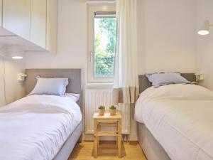 two beds in a small room with a window at Huisje Joep in Goedereede