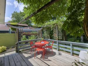 a red table and chairs on a wooden deck at Huisje Joep in Goedereede