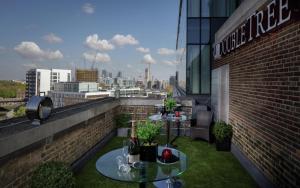 a balcony with two tables and a view of a city at Doubletree By Hilton London - Greenwich in London