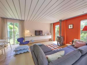a living room with a blue couch and orange walls at Huisje Joep in Goedereede