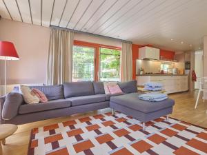 a living room with a blue couch and a kitchen at Huisje Joep in Goedereede