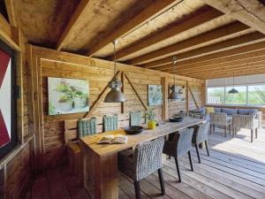 a wooden dining room with a table and chairs at Poldergeluk in Ooltgensplaat