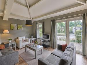 a living room with a couch and a tv at Heidepracht in Putten