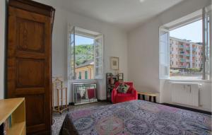 a bedroom with a bed and a chair and two windows at Casa Garibotti in Recco