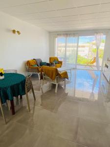 a living room with a table and chairs and a couch at Grand appartement ventilé in Morne-à-lʼEau