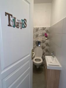 a bathroom with a toilet and a sink at Grand appartement ventilé in Morne-à-lʼEau
