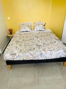 a large bed in a room with a yellow wall at Grand appartement ventilé in Morne-à-lʼEau