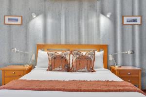 a bedroom with a bed with two night stands and two lamps at The Zoo House in Broome