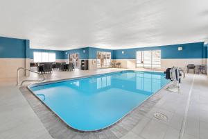 a large swimming pool in a large room with blue water at Hampton Inn & Suites New Castle, PA in New Castle