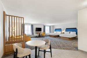 a hotel room with two beds and a table and chairs at Hampton Inn & Suites New Castle, PA in New Castle