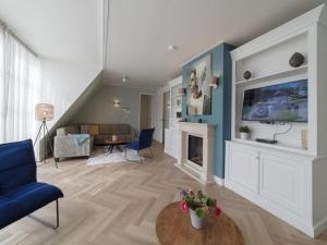 a living room with a couch and a fireplace at Zwembadvilla in Colijnsplaat