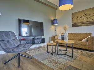 a living room with a couch and a chair and a table at SeaLuxe Residence 27C in Colijnsplaat