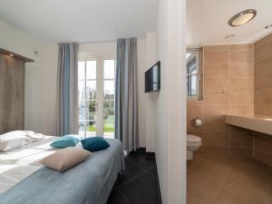 a hotel room with a bed and a bathroom at Zwembadvilla in Colijnsplaat +23 photos