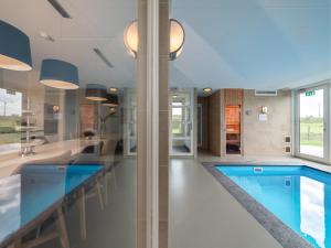 a large kitchen with a swimming pool in a house at Zwembadvilla in Colijnsplaat