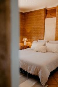 a bedroom with a white bed with a wooden wall at Norfolk House in Dunsborough