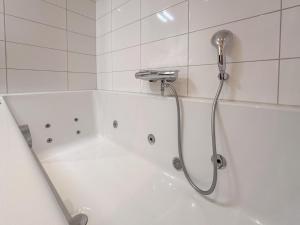 a white bath tub with a shower in a bathroom at Garden de luxe 27B in Colijnsplaat +25 photos