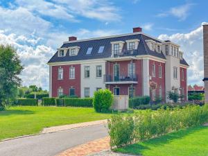 a large red and white house with a yard at Garden de luxe 27B in Colijnsplaat