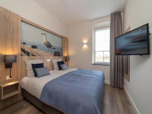 a bedroom with a bed and a tv on a wall at La Mer Luxe in Colijnsplaat