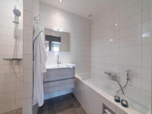 a white bathroom with a tub and a sink at La Mer Luxe in Colijnsplaat +15 photos