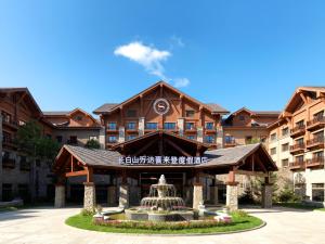 a hotel with a fountain in front of a building at Sheraton Changbaishan Resort in Fusong