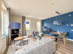 a living room with a couch and a table at Garden de luxe 27B in Colijnsplaat