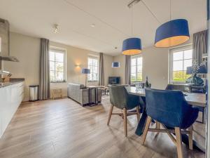 a kitchen and living room with a table and chairs at Garden de luxe 27B in Colijnsplaat