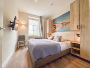a bedroom with a bed with a painting on the wall at Garden de luxe 27B in Colijnsplaat