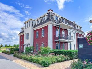 a large red brick building with a balcony at La Mer Luxe in Colijnsplaat