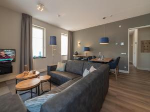 a living room with a couch and a tv at La Mer Luxe in Colijnsplaat