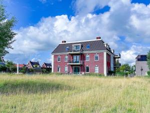 a large red brick house in the middle of a field at Sauna Zee 27A in Colijnsplaat