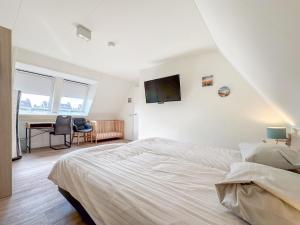 a white bedroom with a bed and a desk at Coast and Calm 63 in Colijnsplaat +30 photos
