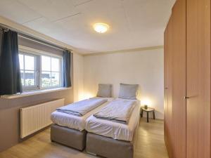 a bedroom with a bed in a room with a window at t Kaatsheuveltje 2 in Kaatsheuvel