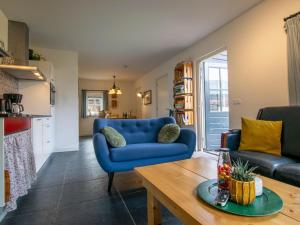 a living room with a blue couch and a table at Op de Beemd in Zeeland