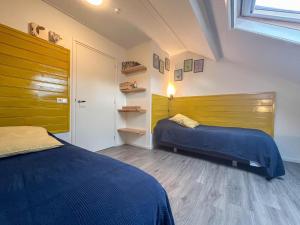a bedroom with two beds and a wooden wall at Op de Beemd in Zeeland