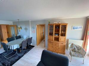 a living room with a dining room table and chairs at Panoramablick-Orther-Hafen-Fehmarn in Orth