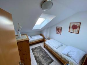 a attic room with two beds and a window at Panoramablick-Orther-Hafen-Fehmarn in Orth