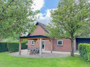 a pavilion with a table and chairs in front of a house at Alpacafarm Vorstenbosch in Vorstenbosch