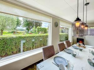 a dining room with a table and a large window at Alpacafarm Vorstenbosch in Vorstenbosch